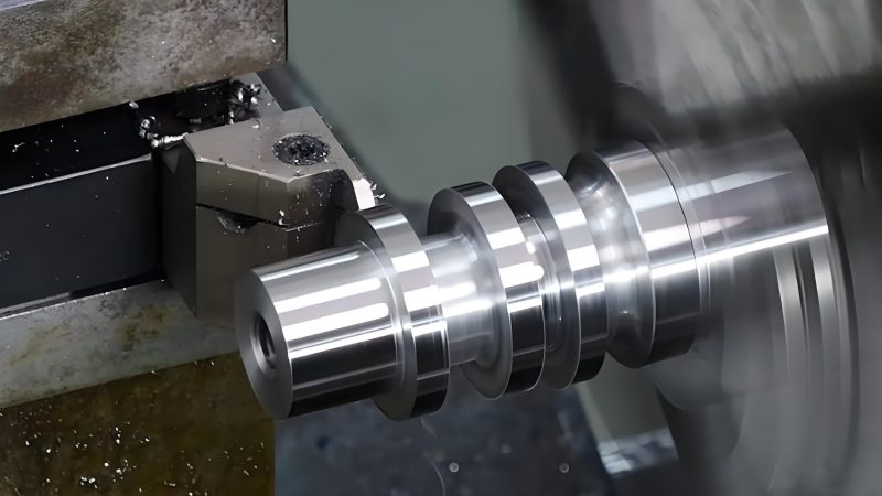 CNC lathe performing precision turning operations on a cylindrical mold component